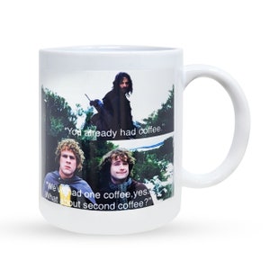 Peut inclure: Une tasse en céramique blanche avec une scène du film Le Seigneur des Anneaux. La tasse présente une image de trois personnages du film avec le texte "You already had coffee." et "We've had one coffee, yes. What about second coffee?"