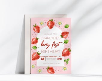 Puede incluir: Invitación de cumpleaños rosa con una ilustración de acuarela de fresas y flores. El texto dice "Únete a nosotros para el primer cumpleaños de Charlotte, 18 de agosto, The Johnson Home, picnic en el jardín de fresas, 2 PM".
