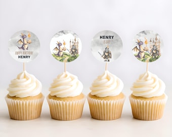 May include: Four cupcakes with white frosting and decorative toppers. The toppers feature watercolor illustrations of a dragon, a knight, and a castle, with the text "HAPPY BIRTHDAY HENRY" and "HENRY IS SIX!" on some. The cupcakes sit on a white surface.