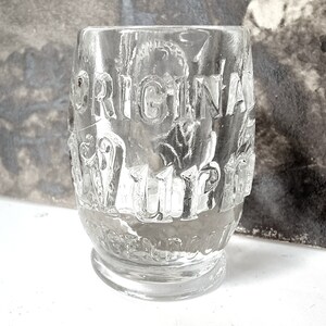 Könnte beinhalten: Ein klares Glas mit der Aufschrift "ORIGINAL WILBUR'S" auf der Seite.