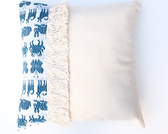 Coussin mexicain blanc brut fait à la main, une pièce unique avec des motifs d’animaux bleus et des franges