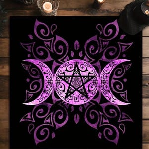 May include: A black decorative mat featuring a purple Triple Moon design with a central pentagram and intricate swirling patterns. The design is set against a black background, with a wooden surface visible around the edges.