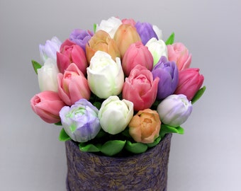 May include: A bouquet of colorful tulips in a round, textured purple box. The tulips are in shades of pink, white, purple, and orange, with green leaves. The box has a gold trim.