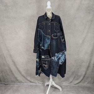 May include: A long denim jacket made from different pieces of denim fabric. The jacket has a patchwork design with different shades of blue denim. The jacket has a collar, button closure, and pockets.