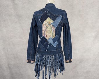 May include: A blue denim jacket with a patchwork design on the back. The jacket has a fringed hem and is on a white mannequin.