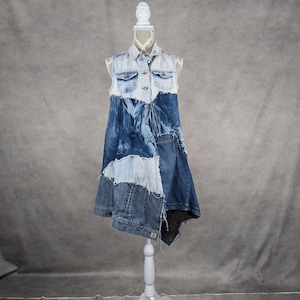 May include: A sleeveless denim dress with a patchwork design. The dress is made of different shades of blue denim and has a frayed hem.