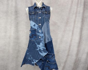 May include: A denim dress crafted from upcycled denim fabric. The dress features a sleeveless bodice and a flowing skirt. The fabric is a blend of blue denim and bleached denim.