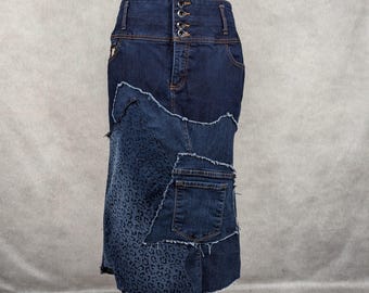 May include: A dark blue denim skirt with a high waist and a leopard print design on the bottom. The skirt is made of multiple pieces of denim sewn together.