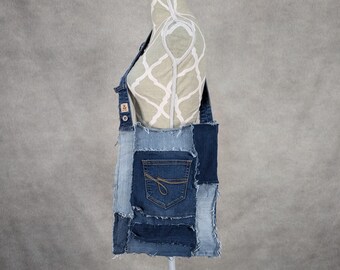 Könnte beinhalten: Eine blaue Jeans-Tragetasche aus wiederverwendetem Jeansstoff. Die Tasche hat ein Patchwork-Design mit verschiedenen Blautönen von Jeans und ausgefransten Kanten.