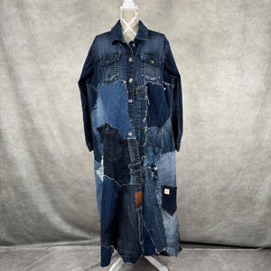Puede incluir: Una chaqueta vaquera larga con un diseño de patchwork. La chaqueta está hecha de diferentes tonos de mezclilla azul y tiene un dobladillo deshilachado.