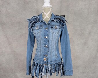 May include: A light blue denim jacket with frayed edges and a fringe trim. The jacket has a button closure and long sleeves.