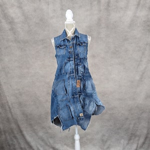 May include: A denim vest dress made from repurposed denim. The dress has a distressed look with frayed edges and multiple pockets.