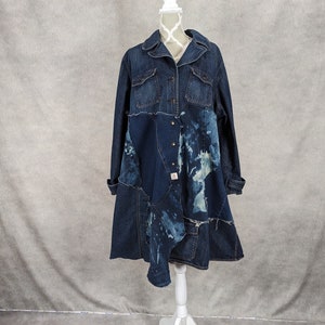May include: A long denim jacket with a patchwork design. The jacket is blue and has a distressed look. It is on a white mannequin.