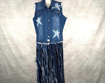May include: A denim vest and skirt ensemble. The vest is a medium wash denim with white star appliqués. The skirt is made of long, shredded denim strips, creating a fringed effect. The outfit is displayed on a white mannequin.