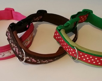 May include: Three dog collars with different patterns. The first collar is pink with a rainbow and unicorn design. The second collar is brown with a floral pattern. The third collar is green with red polka dots.
