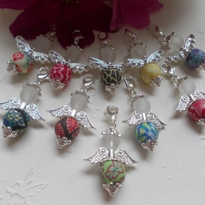 May include: A collection of 10 silver angel charms with colourful patterned beads. Each charm features a white opal-like stone and a silver angel wing design.