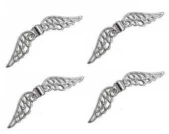 May include: Four silver-colored, filigree-style wing charms. Each wing has a detailed feather design and a cylindrical connector. The charms are arranged against a white background, suggesting a craft or jewelry theme.