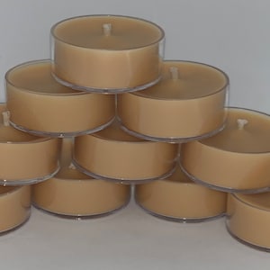May include: A stack of ten unscented tea light candles in clear plastic containers. The candles are a light brown color.