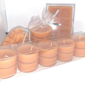 May include: A set of unscented tea light candles in a clear plastic container. The candles are a light orange color and are arranged in rows. There are also some loose tea light candles in a plastic bag.