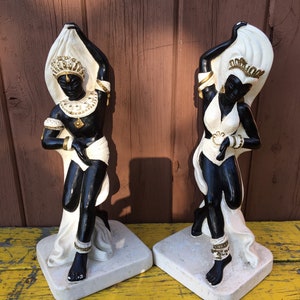 Peut inclure: Une paire de figurines en céramique noire et blanche de danseurs avec des accents dorés. Les figurines sont posées sur des socles blancs.