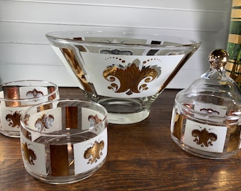 Puede incluir: Un juego de cuatro cuencos de vidrio vintage con diseños florales dorados y blancos. El juego incluye un cuenco grande, dos cuencos más pequeños y un tarro con tapa.