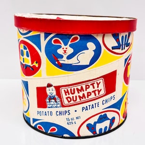 Puede incluir: Una lata vintage cilíndrica de color rojo, blanco y azul de patatas fritas Humpty Dumpty. La lata presenta una ilustración de dibujos animados de Humpty Dumpty y otros personajes caprichosos. El texto en la lata dice "Humpty Dumpty Potato Chips - Patate Chips 15 oz. Net 425 g."