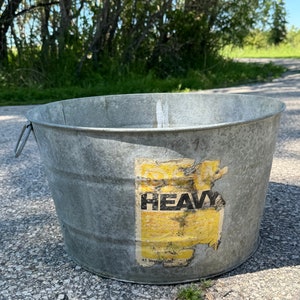 May include: A galvanised metal bucket with a yellow and black label that reads "Heavy Duty 4.5 Litres/1 Gallon".