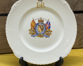 May include: White ceramic plate with a gold rim and a decorative design featuring a crown, the letters "E II R", and a crest with the text "HM QUEEN ELIZABETH II" and "CORONATION JUNE 2ND 1953".