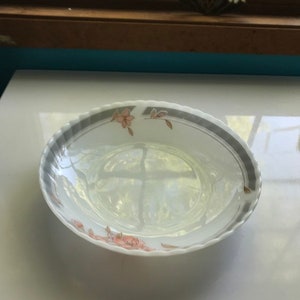 Può includere: Piatto da portata ovale bianco con bordo grigio e nero e decorazioni floreali. La ciotola ha un bordo smerlato ed è decorata con disegni floreali rosa e oro. Un pezzo classico per servire.