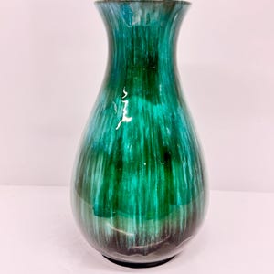 May include: A green and blue ceramic vase with a wide mouth and a rounded body. The vase has a glossy finish and a streaky glaze.