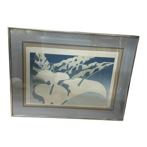 May include: Framed art print featuring a stylized floral design in shades of white and blue. The artwork is encased in a silver-toned frame with a light gray matting, creating a modern aesthetic. The print showcases a minimalist approach to botanical art.