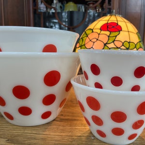 以下が含まれることがあります： 赤い水玉模様の白いミキシングボウル4個セット。ボウルは互いに重ねられています。