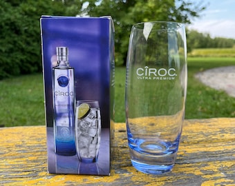 May include: A blue and silver bottle of Ciroc Ultra Premium Vodka with a lime wedge and ice in a tall glass. The bottle is in front of a blue and white box with the Ciroc logo.