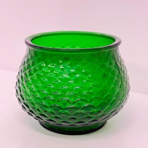 Op de afbeelding: Een groene glazen vaas met een getextureerd, bubbelvormig ontwerp. De vaas is rond en heeft een brede opening.