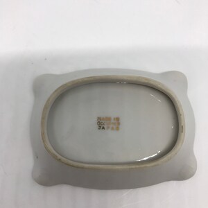 May include: White ceramic dish with a scalloped edge. The bottom of the dish has the text "Made in Occupied Japan" printed in gold.