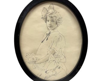 May include: Oval black framed pencil sketch of a young person with curly hair, wearing a dress with bows. The sketch is on a cream-coloured background. The frame is a simple, classic design.