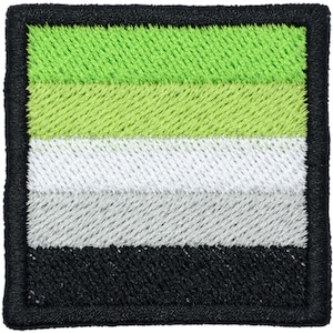 May include: A square embroidered patch featuring five horizontal stripes in descending order of dark green, light green, white, light gray, and black. The entire design is framed by a thick, black stitched border with rounded corners.