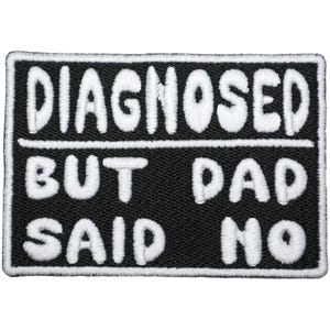 Può includere: Toppa rettangolare nera con testo bianco ricamato. Il testo recita "DIAGNOSED" sopra "BUT DAD SAID NO". La toppa ha un bordo bianco.