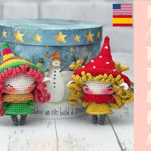 Puede incluir: Dos muñecos de gnomo de crochet con pelo de lana rojo y amarillo. El gnomo de la izquierda lleva un gorro verde con rayas amarillas y rojas y un vestido verde. El gnomo de la derecha lleva un gorro rojo con lunares blancos y un vestido amarillo. Ambos gnomos tienen una cara blanca con mejillas rojas y ojos negros.