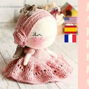 Op de afbeelding: Haakpoppenpatroon in roze en wit met een kroon en een roos. Het patroon is beschikbaar in het Engels, Spaans en Frans.