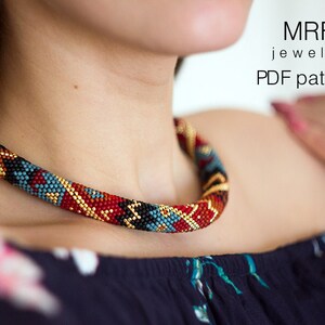 Puede incluir: Un collar de cuentas con un diseño tubular. El collar presenta un patrón de cuentas rojas, negras, azules y doradas. El texto "MRF jewelry PDF pattern" es visible en la esquina superior derecha.