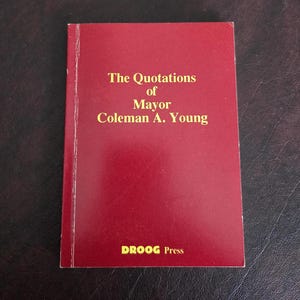 May include: A red book with the title "The Quotations of Mayor Coleman A. Young" and the words "DROOG Press" printed on the bottom.
