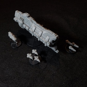 以下が含まれることがあります： グレーのプラスチック製のミニチュア宇宙船のセット。大型の巡洋艦と小型の戦闘機がいくつか含まれています。船は黒い台座の上にあります。