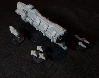May include: A set of grey plastic miniature spaceships, including a large cruiser and several smaller fighters. The ships are on black bases.