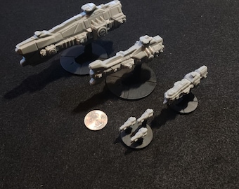 May include: Four gray plastic miniature spaceships of varying sizes on black bases. The largest spaceship is about the size of a U.S. quarter.