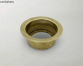 May include: A round, brass-colored metal drain cover with a raised rim.
