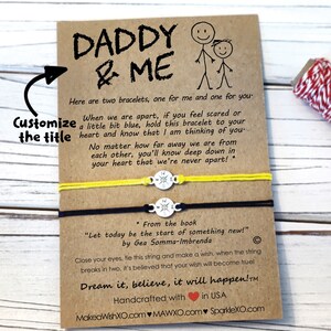 Pu&ograve; includere: Due braccialetti dell'amicizia con cordino giallo e nero, legati insieme con un ciondolo a forma di bussola. La carta recita "Pap&agrave; & Io" e include un messaggio sui braccialetti che rappresentano un legame che &egrave; sempre vicino, indipendentemente dalla distanza. La carta include anche la citazione "Che oggi sia l'inizio di qualcosa di nuovo!" di Gea Somma-Imbrenda.