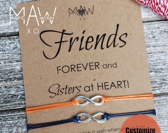 May include: Two friendship bracelets with infinity symbols, one orange and one blue, on a brown card with the text "Friends Forever and Sisters at Heart!" and instructions to customize the card.