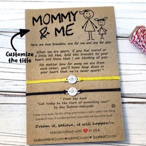 Pu&ograve; includere: Due braccialetti dell'amicizia con cordino giallo e nero, legati insieme con un ciondolo a forma di bussola. La carta recita "Mamma & Io" e include un messaggio sui braccialetti come promemoria di amore e connessione. La carta include anche il testo "Sognalo, credici, accadr&agrave;!"
