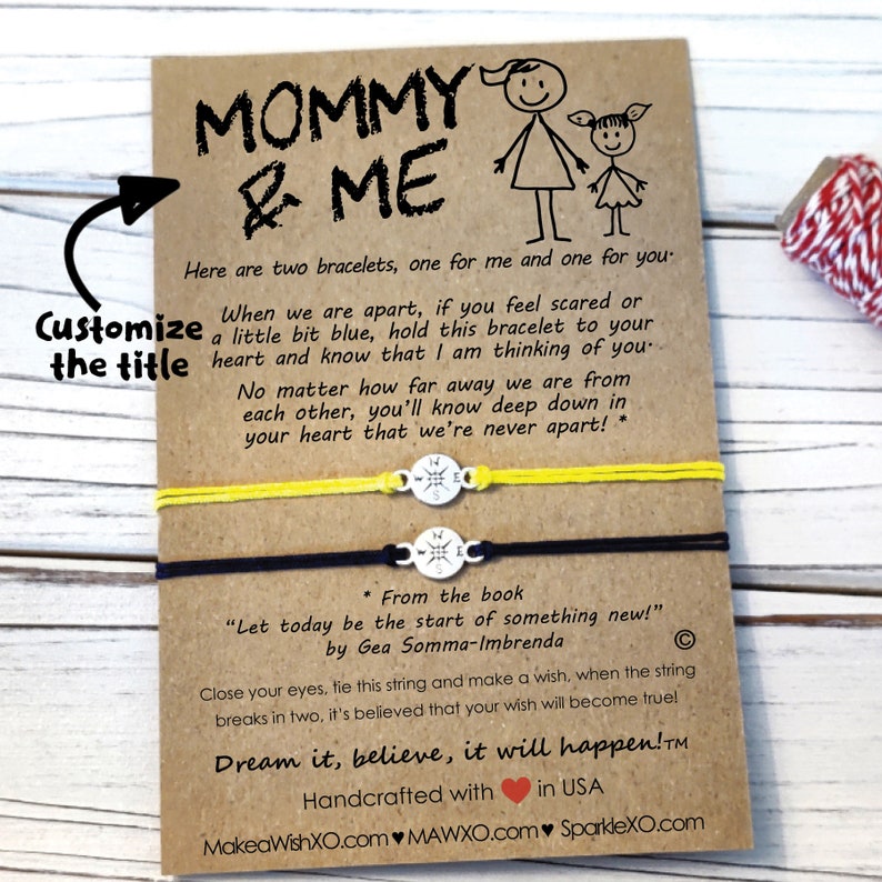Pu&ograve; includere: Due braccialetti dell'amicizia con cordino giallo e nero, legati insieme con un ciondolo a forma di bussola. La carta recita "Mamma & Io" e include un messaggio sui braccialetti come promemoria di amore e connessione. La carta include anche il testo "Sognalo, credici, accadr&agrave;!"